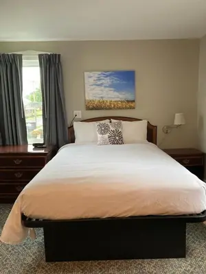 a bedroom with a large bed and a window at Country Squire Inn and Suites in New Holland