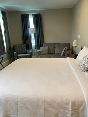 a large white bed in a living room with a couch at Country Squire Inn and Suites in New Holland