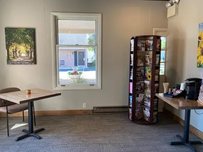 a room with a window and a table and a refrigerator at Country Squire Inn and Suites in New Holland
