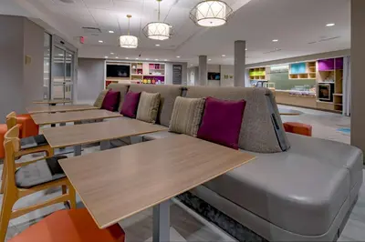 a row of tables and a couch in a restaurant at Home2 Suites By Hilton Wayne, NJ in Wayne