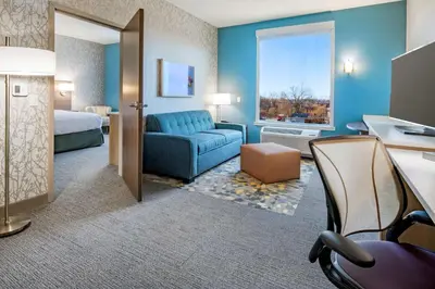 a hotel room with a bed and a couch and a desk at Home2 Suites By Hilton Wayne, NJ in Wayne