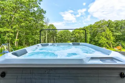 a large hot tub in a yard with trees at Peaceful Mountian Oasis Firepit, Hot Tub, Sauna! in Vernon Township