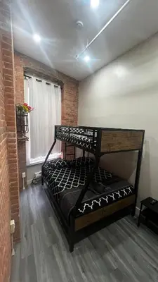 a bedroom with a black bunk bed in a room at 31 Street Broadway Hotel in New York