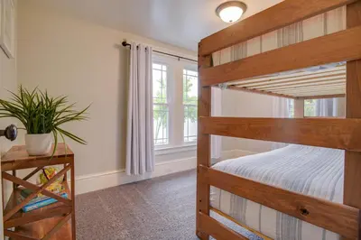 a bedroom with two bunk beds and a window at Waterfront Home with Hot Tub in Wrightsville! in Wrightsville