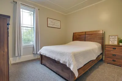 a bedroom with a bed and a dresser and a window at Waterfront Home with Hot Tub in Wrightsville! in Wrightsville