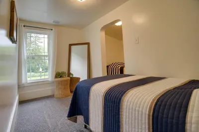 a bedroom with a bed and a mirror and a window at Waterfront Home with Hot Tub in Wrightsville! in Wrightsville