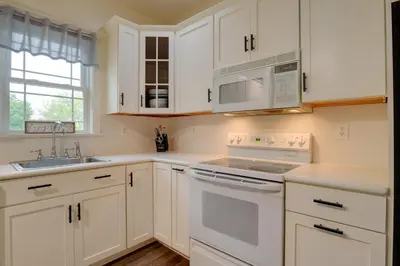 a white kitchen with white appliances and a sink at Waterfront Home with Hot Tub in Wrightsville! in Wrightsville
