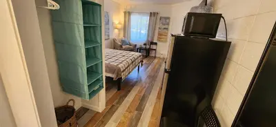 a room with a bed and a tv on a refrigerator at Rolling Hills Motel in Wantage