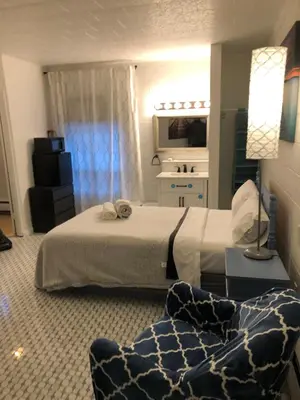 a hotel room with a bed and a chair at Rolling Hills Motel in Wantage