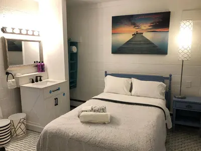 a bedroom with a bed with a sink and a mirror at Rolling Hills Motel in Wantage