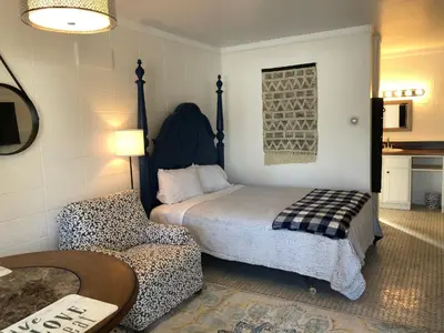 a bedroom with a bed and a chair and a table at Rolling Hills Motel in Wantage