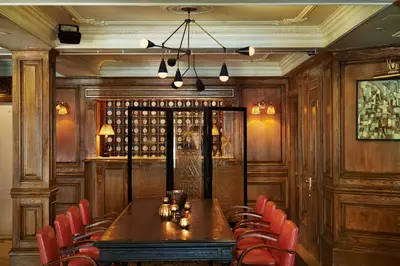 a dining room with a long table and red chairs at The Marlton Hotel in New York