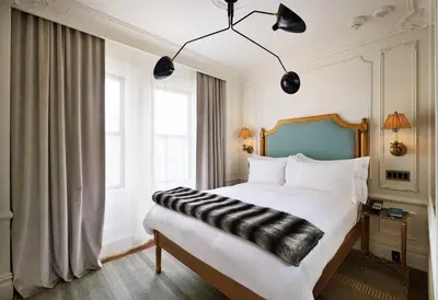 a bedroom with a large bed with a black and white comforter at The Marlton Hotel in New York