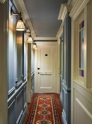 a hallway with a white door and a rug at The Marlton Hotel in New York