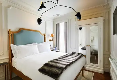 a bedroom with a white bed with a black blanket at The Marlton Hotel in New York