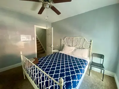 a bedroom with a blue and white bed and a ceiling fan at Clover 2900 - Apartment and Rooms with Private Bathroom near Washington Ave South Philly in Philadelphia