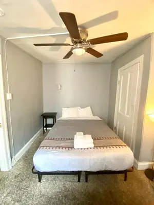 a bedroom with a bed with a ceiling fan at Clover 2900 - Apartment and Rooms with Private Bathroom near Washington Ave South Philly in Philadelphia