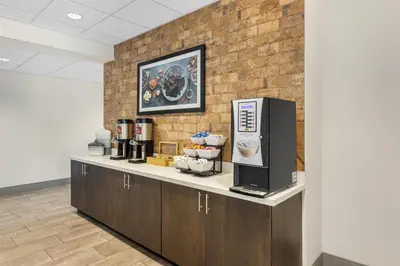 a coffee shop with a counter and a brick wall at Best Western Plus Hershey in Hershey