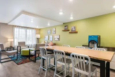 a living room and dining room with a table and chairs at WoodSpring Suites Linden in Linden