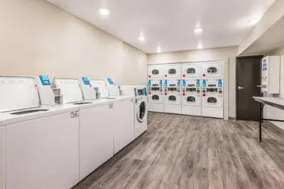 a laundry room with white washers and dryers at WoodSpring Suites Linden in Linden