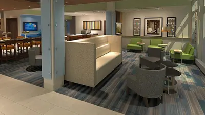 a lobby with a restaurant with green chairs and tables at Holiday Inn Express & Suites - Lancaster - Mount Joy by IHG in Mount Joy