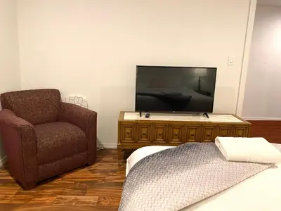 a living room with a television and a chair at AF Stays - Philadelphia Convention Center in Philadelphia