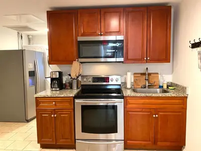 a kitchen with wooden cabinets and a stainless steel appliance at AF Stays - Philadelphia Convention Center in Philadelphia