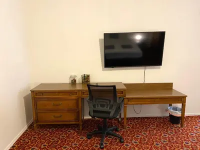a desk with a chair and a television on a wall at AF Stays - Philadelphia Convention Center in Philadelphia