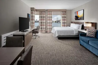 a hotel room with a bed and a flat screen tv at Hilton Garden Inn Camden Waterfront Philadelphia in Camden