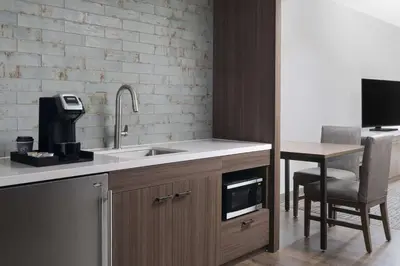 a kitchen with a sink and a table with a tv at Hilton Garden Inn Camden Waterfront Philadelphia in Camden