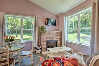 a living room with a fireplace and a table at Relax Fireside! Retreat 16 Mi to Camelback Resort in Saylorsburg