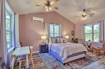 a bedroom with a bed and a desk and windows at Relax Fireside! Retreat 16 Mi to Camelback Resort in Saylorsburg