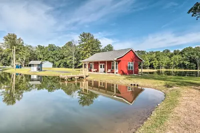 a red cabin next to a body of water at Relax Fireside! Retreat 16 Mi to Camelback Resort in Saylorsburg