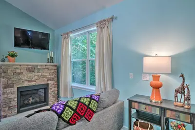 a living room with a couch and a fireplace at 16 Mi to Ski Slopes! Creekside Poconos Cottage in Brodheadsville