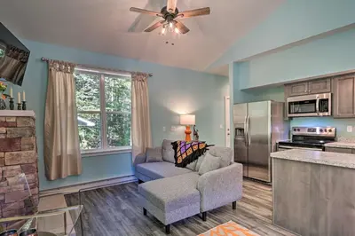 a living room with a couch and a kitchen at 16 Mi to Ski Slopes! Creekside Poconos Cottage in Brodheadsville