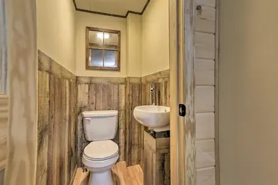 a bathroom with a toilet and a sink at Quaint Lake Cottage with Pool and Beach Access! in Pocono Lake