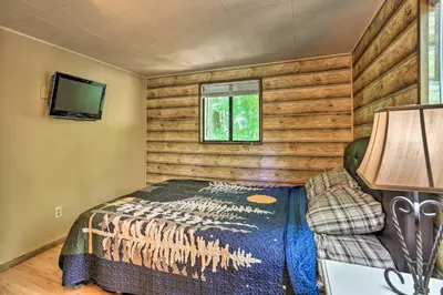a bedroom with a bed and a tv in a room at Quaint Lake Cottage with Pool and Beach Access! in Pocono Lake