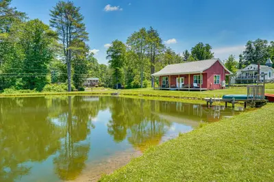 a house with a pond in front of a house at Close to Slopes Lakeside Cottage in Pocono Mtns in Brodheadsville