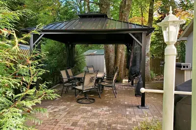 a pavilion with chairs and a table on a brick patio at Paradise in heart of Poconos FaSt InTeRnEt Close to All Attractions in Pocono Summit