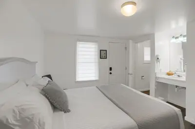 a white bedroom with a bed and a sink at Halifax Inn in Halifax