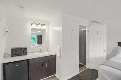 a white bathroom with a sink and a bed at Halifax Inn in Halifax