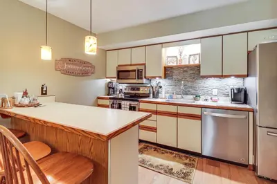 a large kitchen with a counter and a refrigerator at Walk to Dining! Townhome 1 Mi to Big Boulder Mtn in Lake Harmony