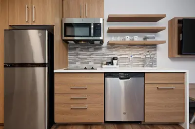 a kitchen with a stainless steel refrigerator and microwave at Element New York Wood Ridge in Wood-Ridge