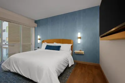 a bedroom with a white bed and a blue wall at Element New York Wood Ridge in Wood-Ridge
