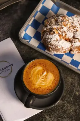 a cup of coffee next to a plate of doughnuts at Residence Inn By Marriott Philadelphia Bala Cynwyd in Bala-Cynwyd