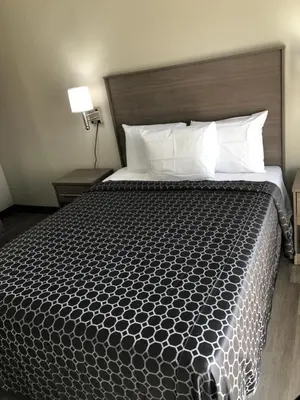 a bedroom with a large bed with a wooden headboard at Trolley Stop Motel, Media ,Near PHL Airport PA in Media