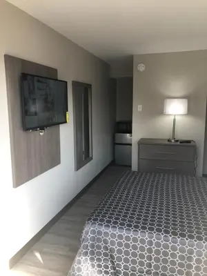 a bedroom with a bed and a flat screen tv at Trolley Stop Motel, Media ,Near PHL Airport PA in Media