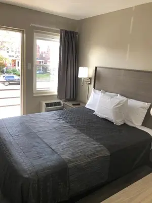 a bedroom with a large bed with a large window at Trolley Stop Motel, Media ,Near PHL Airport PA in Media