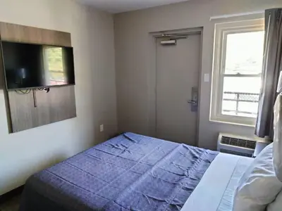 a bedroom with a bed and a tv and a window at Trolley Stop Motel, Media ,Near PHL Airport PA in Media