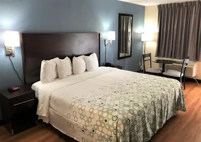 a hotel room with a large bed and a desk at HomeTowne Studios by Red Roof Bordentown - McGuire AFB in Bordentown